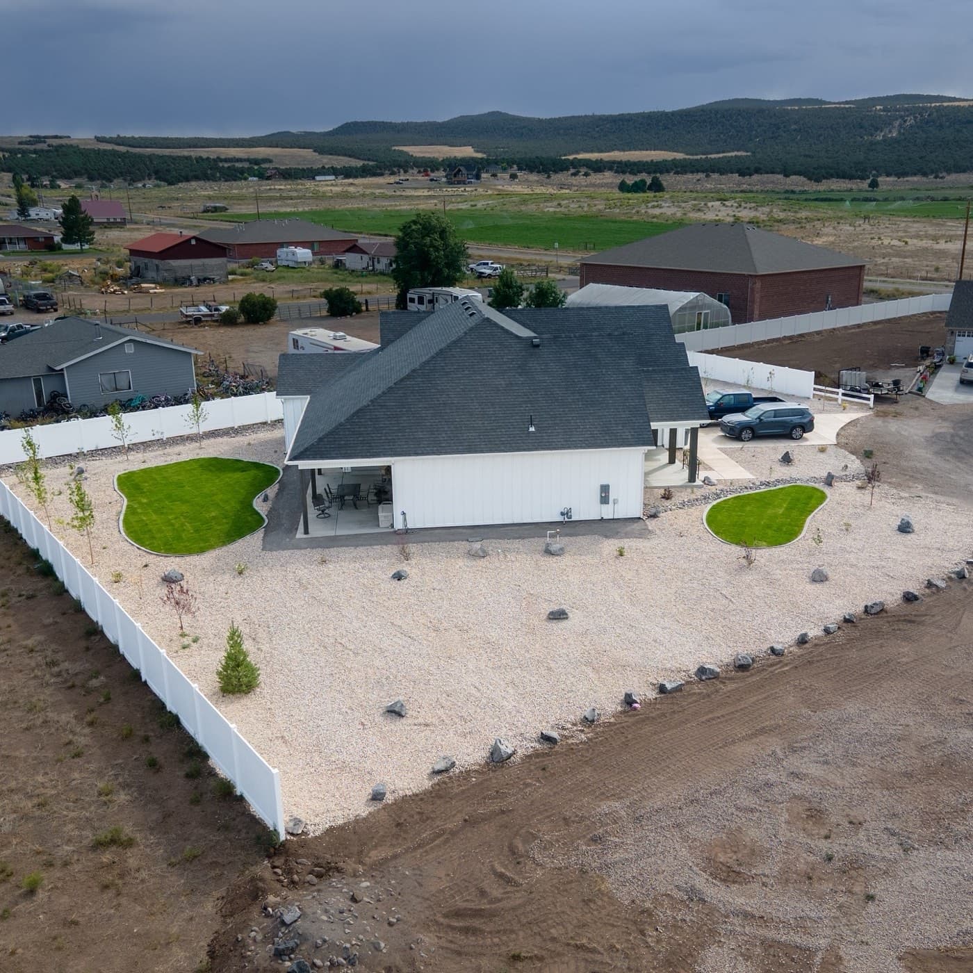 Aerial view of a completed Full Curl Landscaping property — custom lawn shaping, rock beds, and full property landscaping