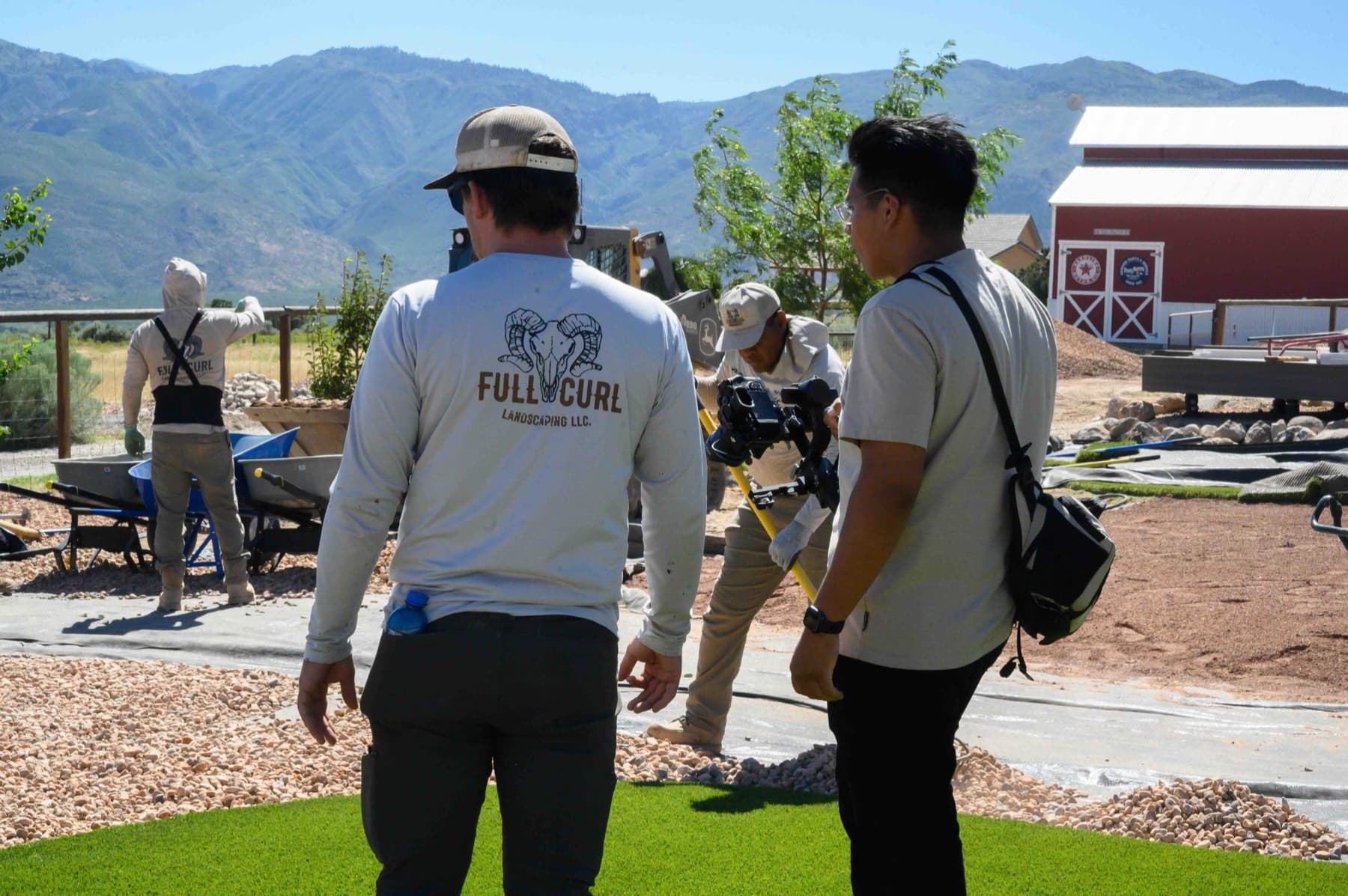 The Full Curl Landscaping crew on-site during a project shoot, mountains in the background